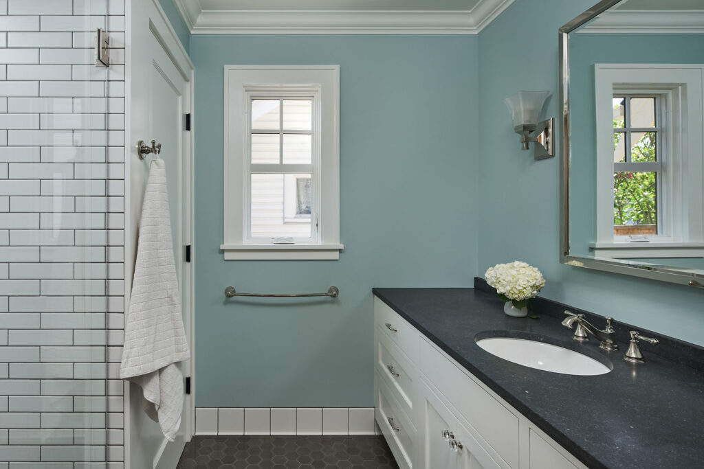 The primary bathroom at the aging in place remodel has a walk-in shower, a large sink vanity, and a private toilet room.