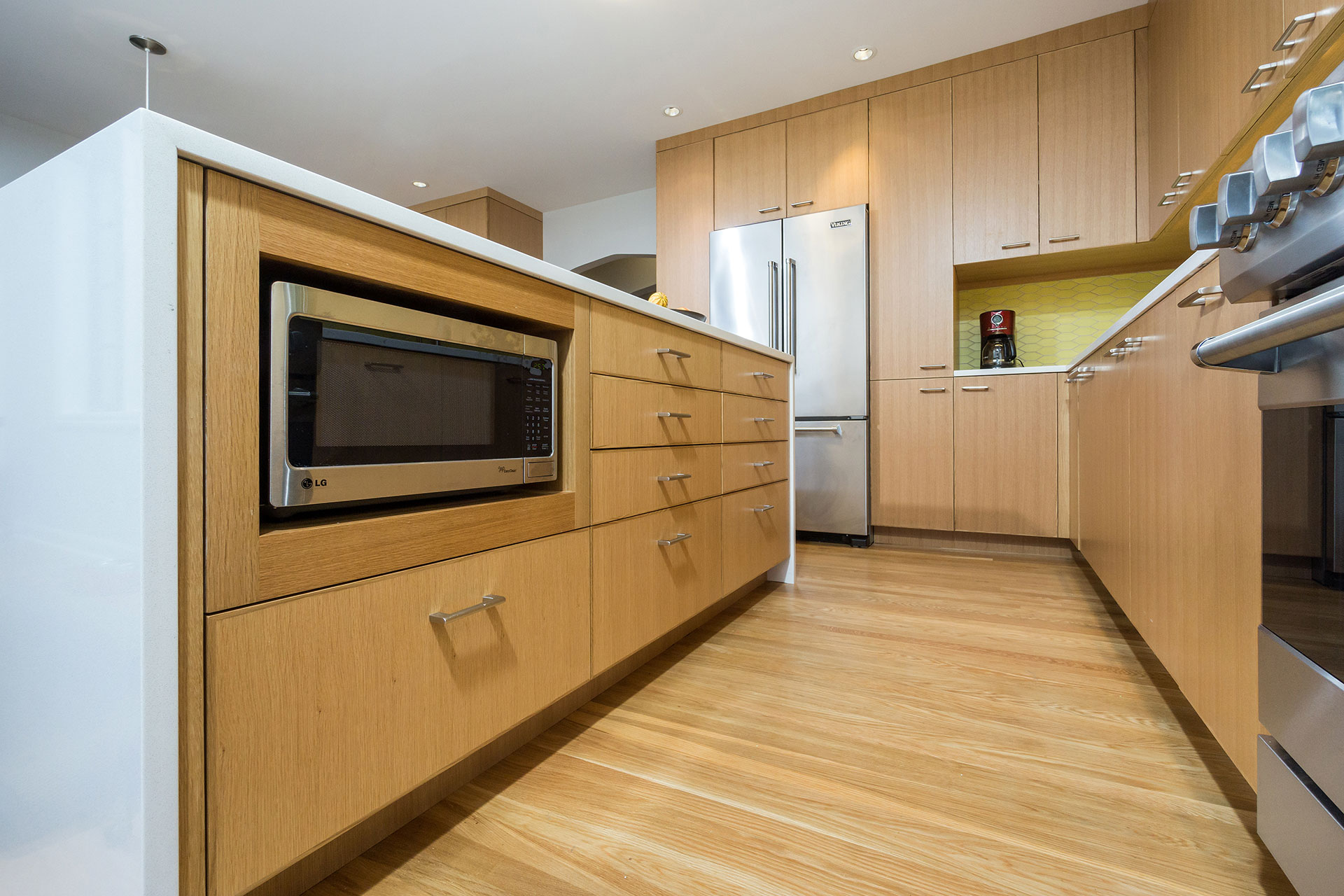 At the Alameda Modern, the renovated kitchen features an island that acts as a buffer between the prep and dining areas. The island houses a niche for a microwave.
