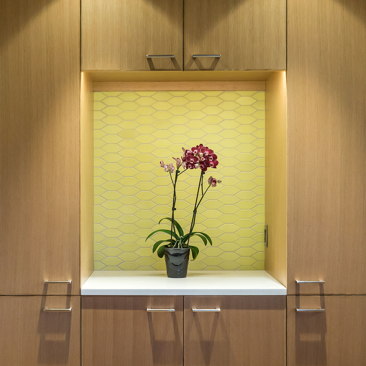 A niche in the cabinetry features a tiled backsplash and offers a place to display an orchid plant at the Alameda Update.