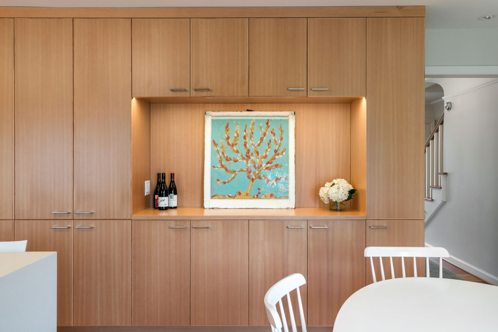 A niche in the cabinetry provides space for wine storage and art in this kitchen remodel.