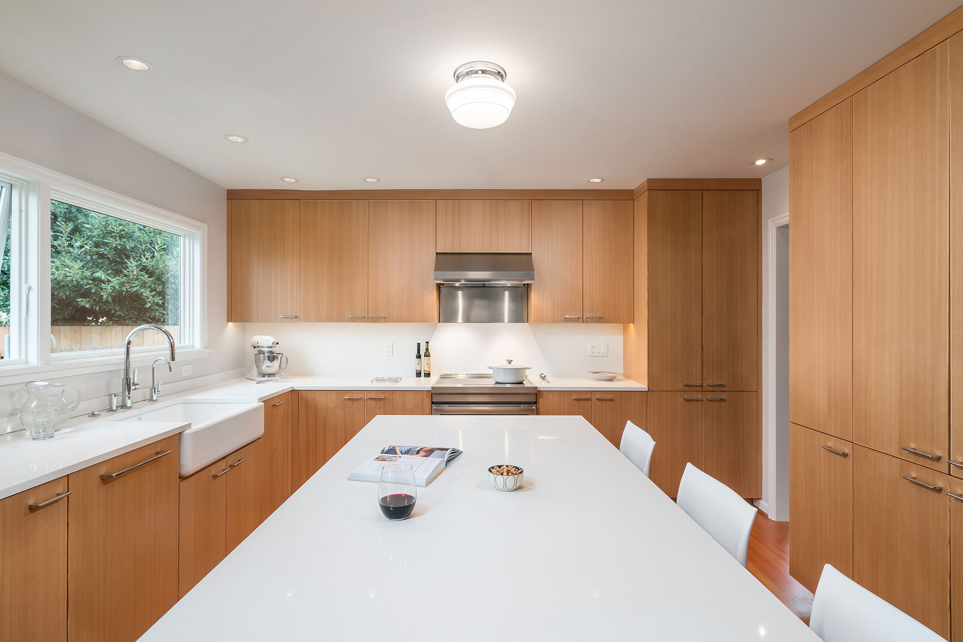 A large island with a waterfall counter separates the eating area from the prep area in the kitchen remodel.