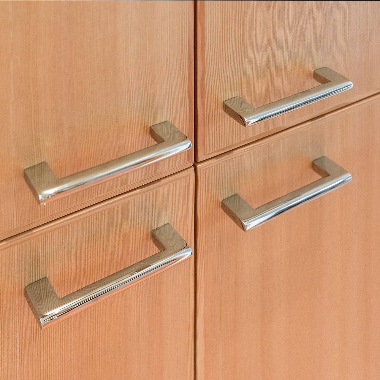 Shiny chrome cabinet pulls adorn the fir wood cabinetry at the Concordia Renovation.