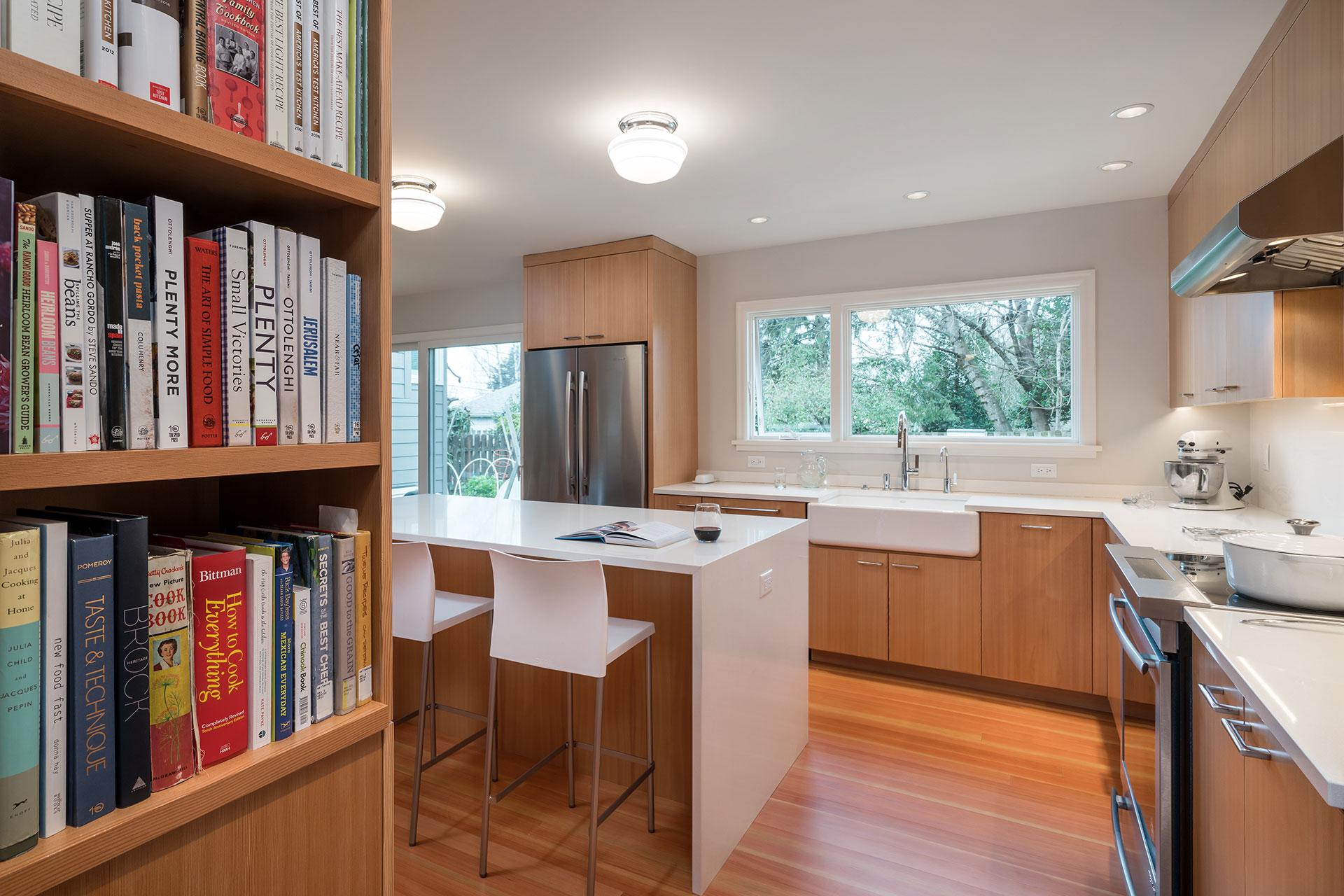 Bookshelves are built into the ends of the cabinetry in this kitchen remodel.