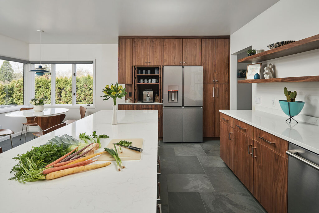 Kitchen and bath remodel features walnut cabinetry, white quartz counters, and black slate floors.