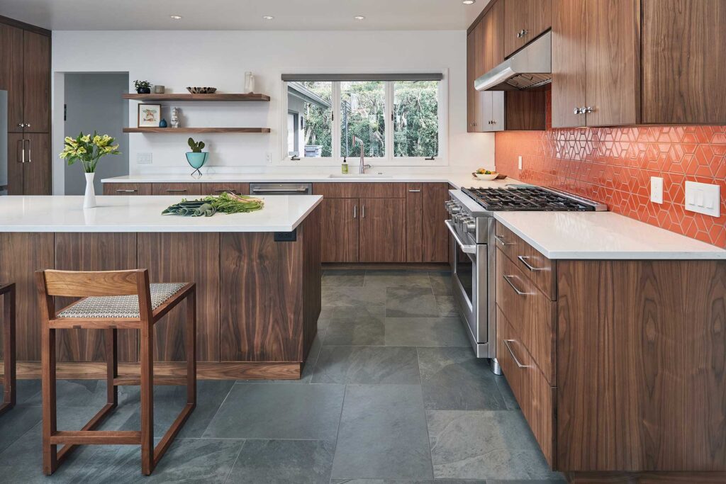 Kitchen and bath remodel features walnut cabinetry, white quartz counters, orange backsplash tile, and black slate floors.