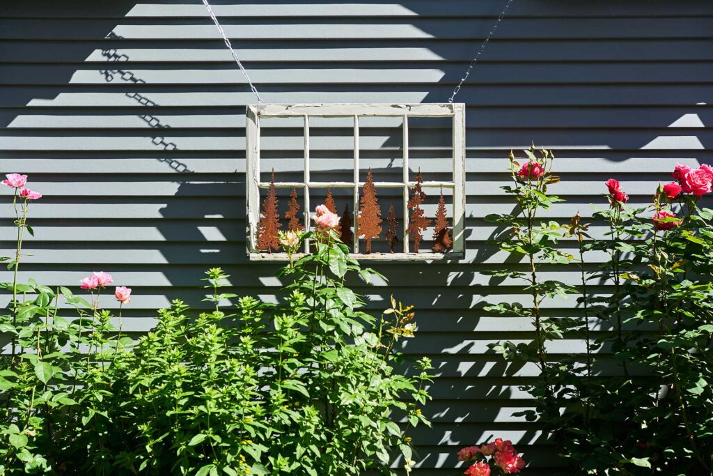 An old window from the former garage is hung as artwork on the exterior of the new garage design.