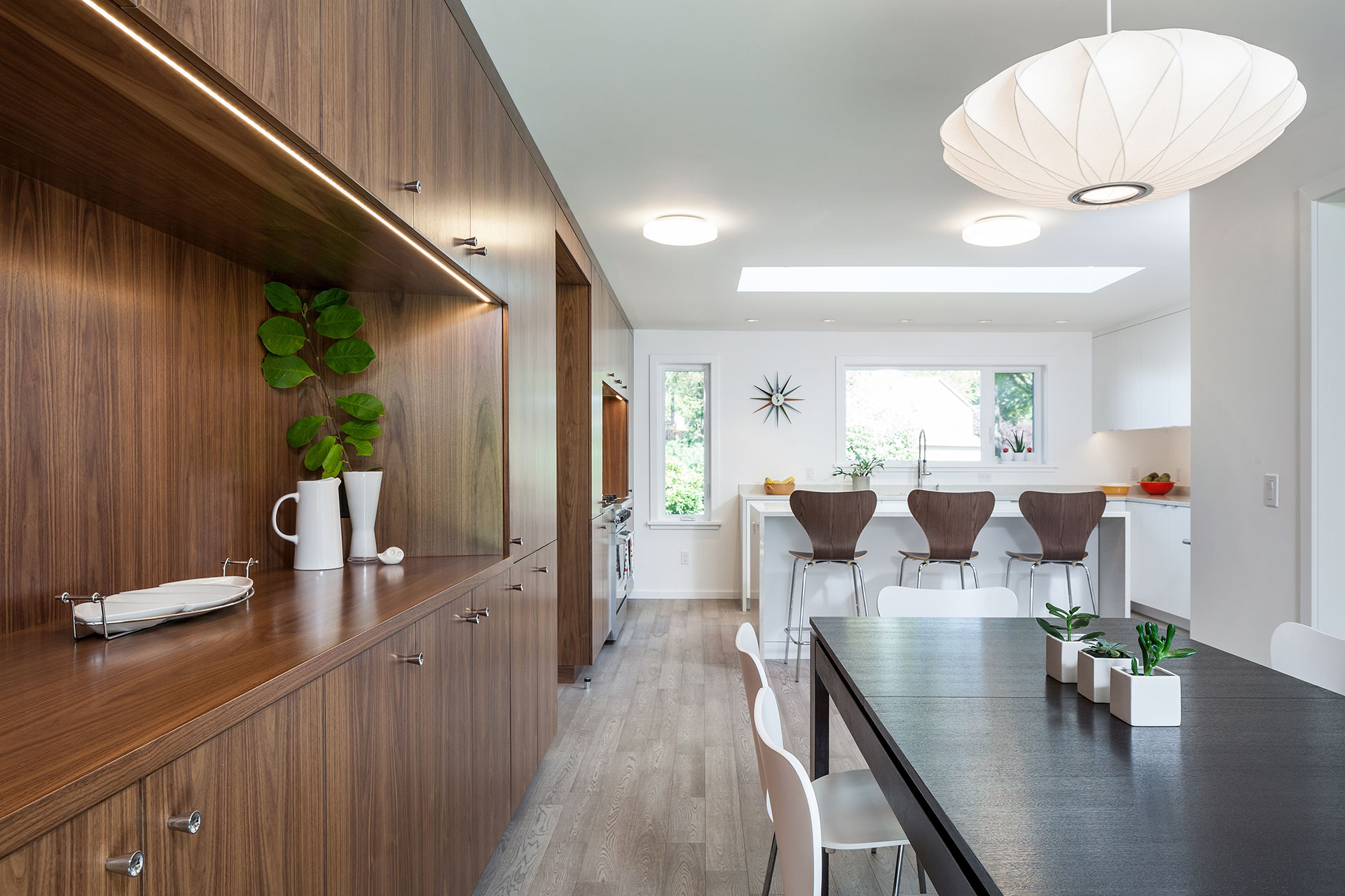 Walnut cabinets span from the dining room through to the kitchen after the residential remodel.