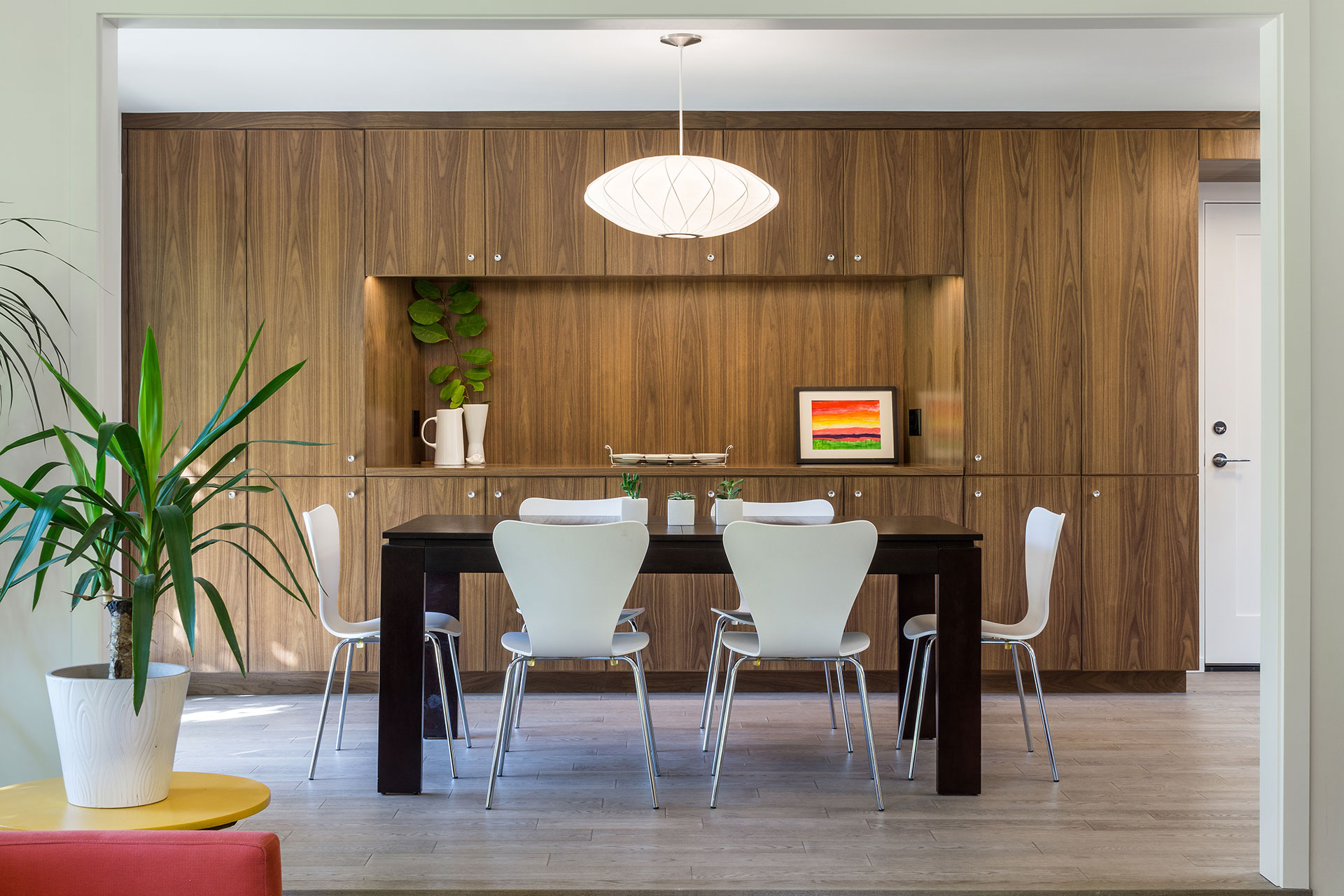 The renovated dining room after the residential remodel features a built-in buffet crafted of plain-sliced walnut.