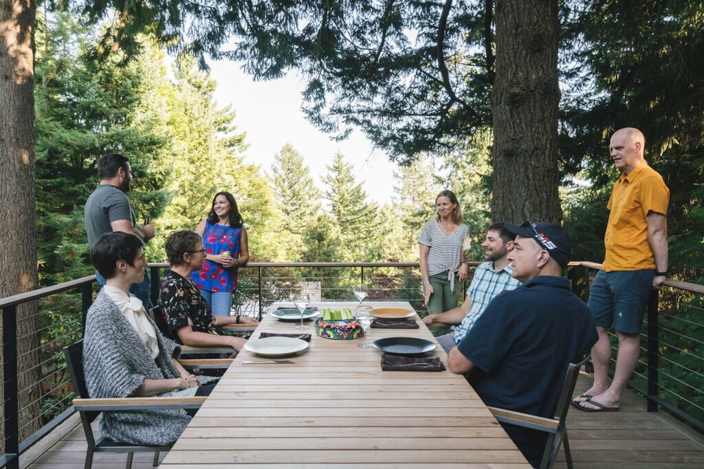 The upper level of the multilevel deck features a large teak dining table.