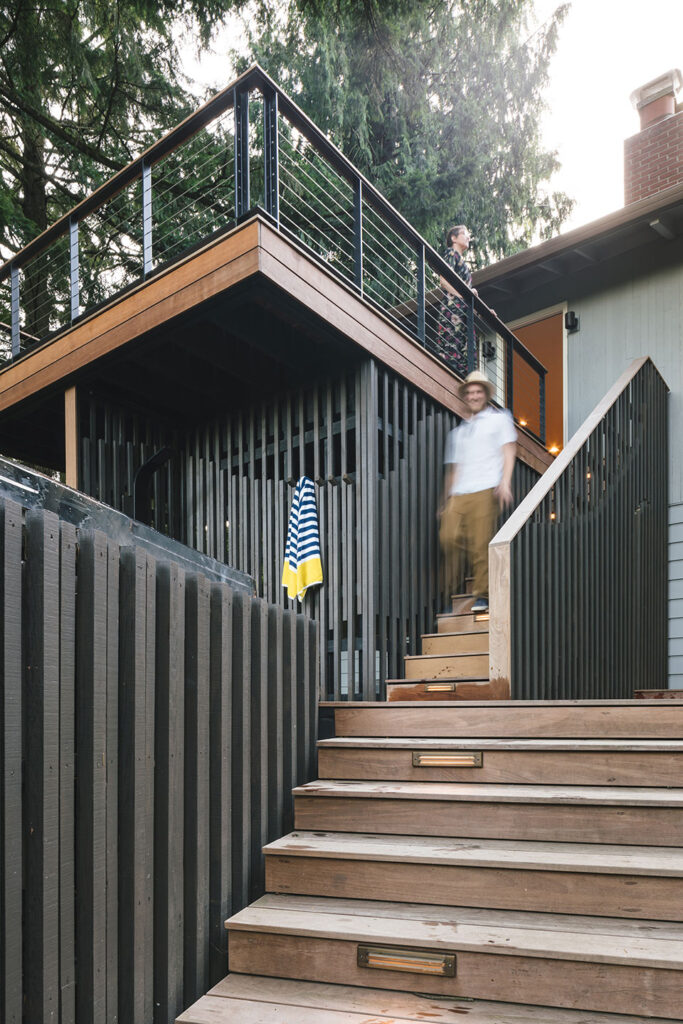 The stairs at the multilevel deck are crafted with ipe-wood. The vertical enclosure walls are black-stained cedar.