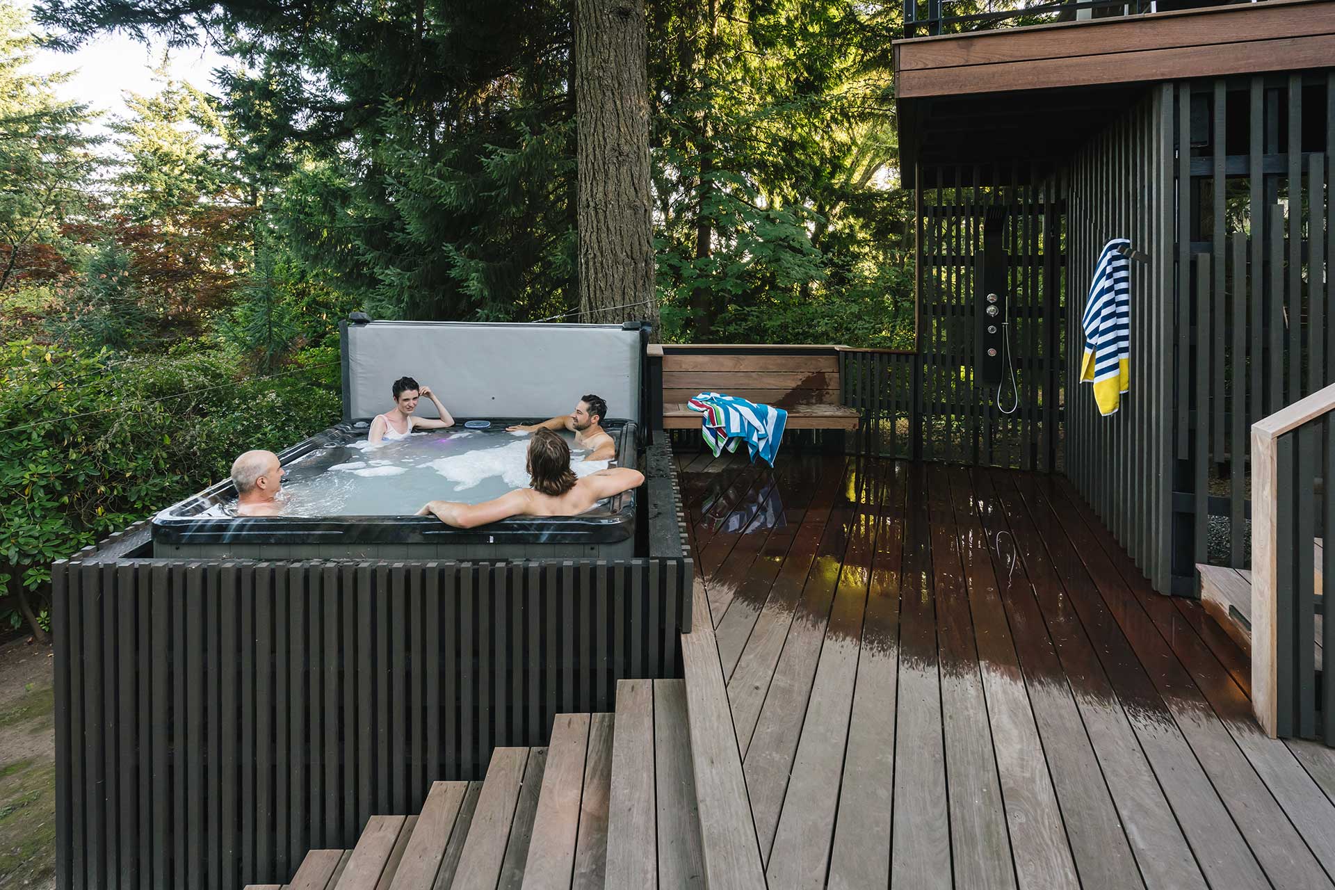 A hot tub is next to the outdoor shower on the lower level of the deck.