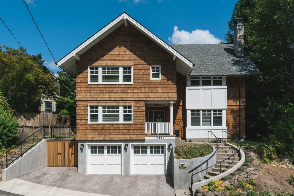 The home after the down to the studs house remodel is three stories tall with a tuck under garage.