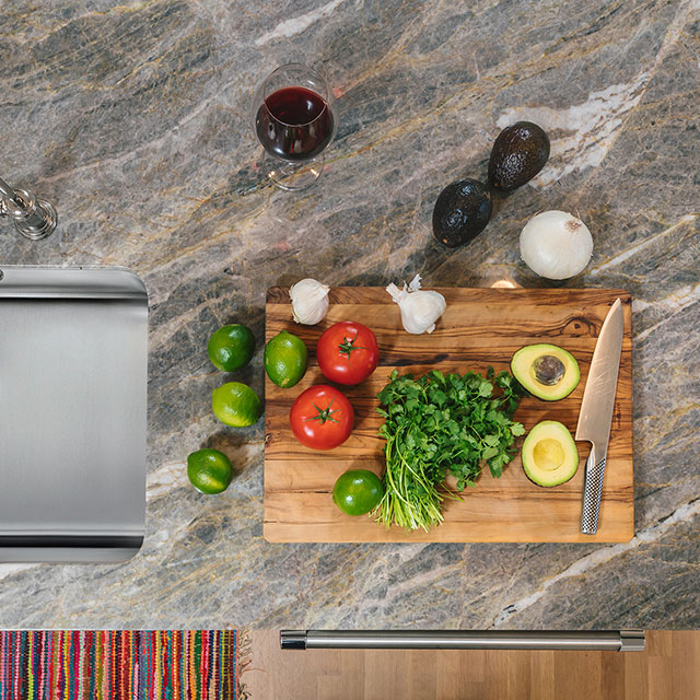 Granite countertops and a stainless steel sink provide beautiful yet durable surfaces for meal prep in the Hillside House kitchen.
