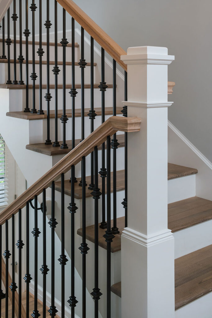 White newel post, black iron balusters, white oak handrail, white oak stair treads.