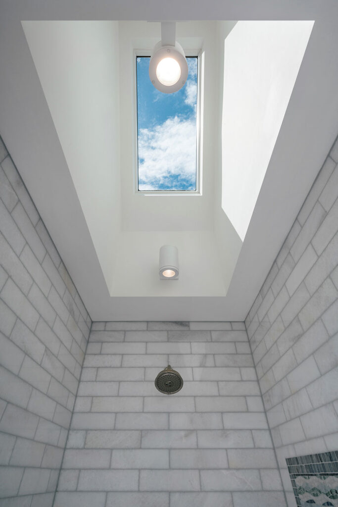 A large skylight brightens the primary bathroom shower at the Hillside House.