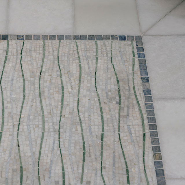 Custom mosaic tile is featured on the shower floor at the Hillside House.