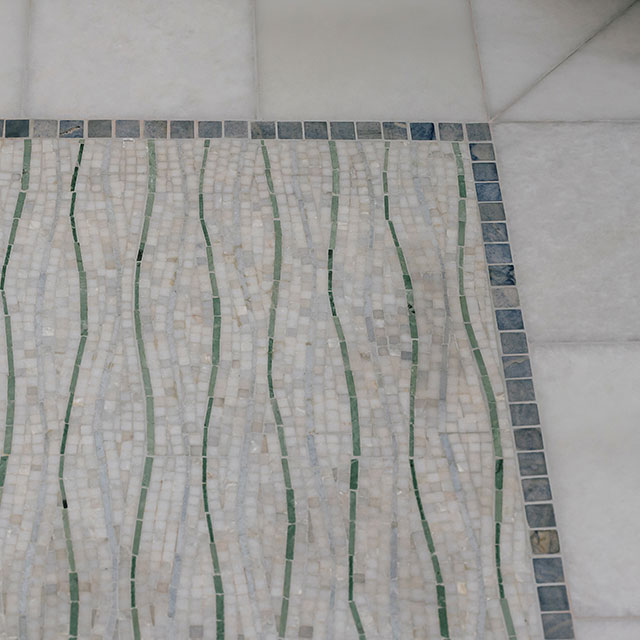 Blue and white marble mosaic tile on bathroom floor.