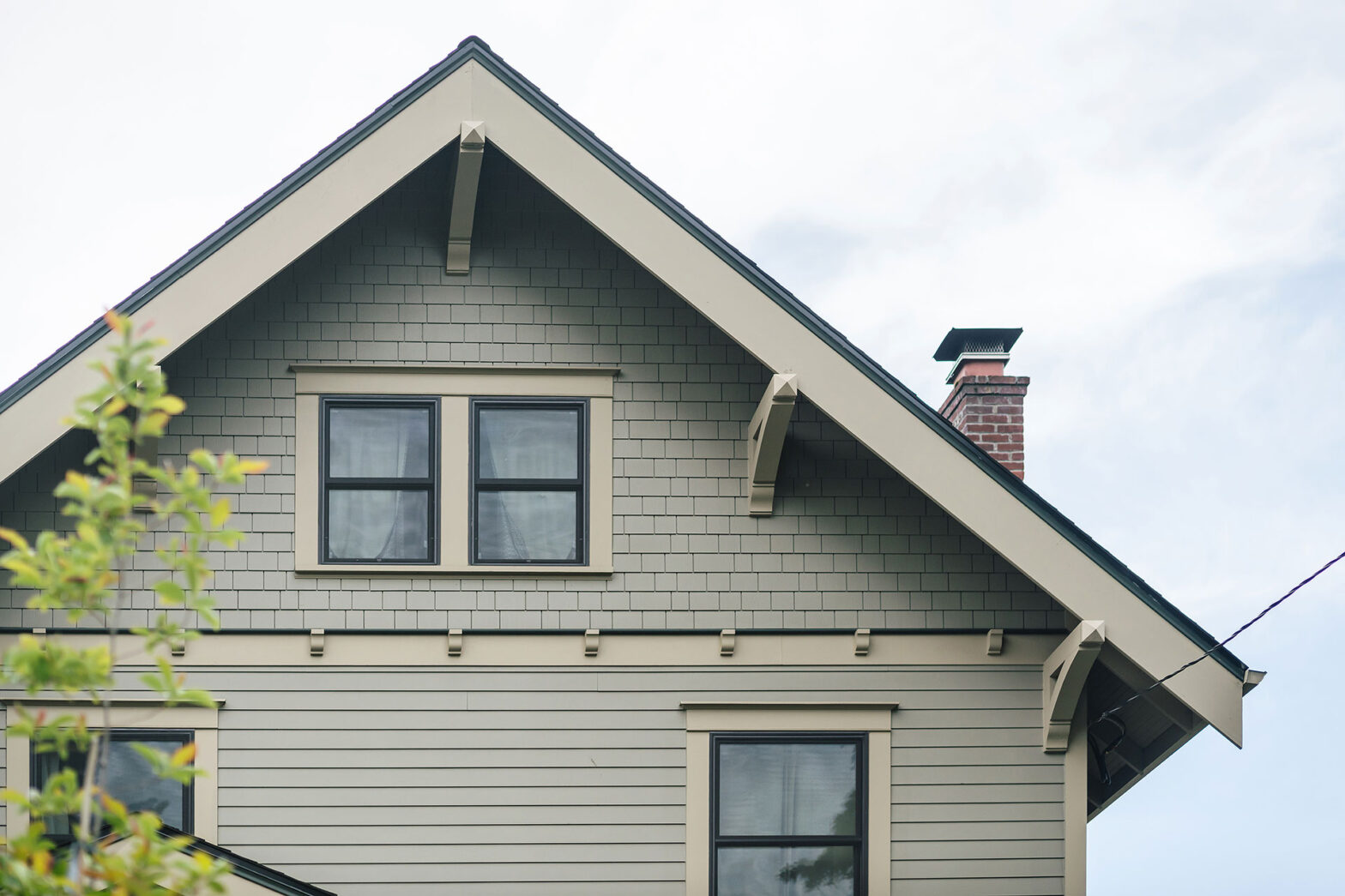 Traditional craftsman house with custom eave brackets, shingles, lap siding, and corbels.