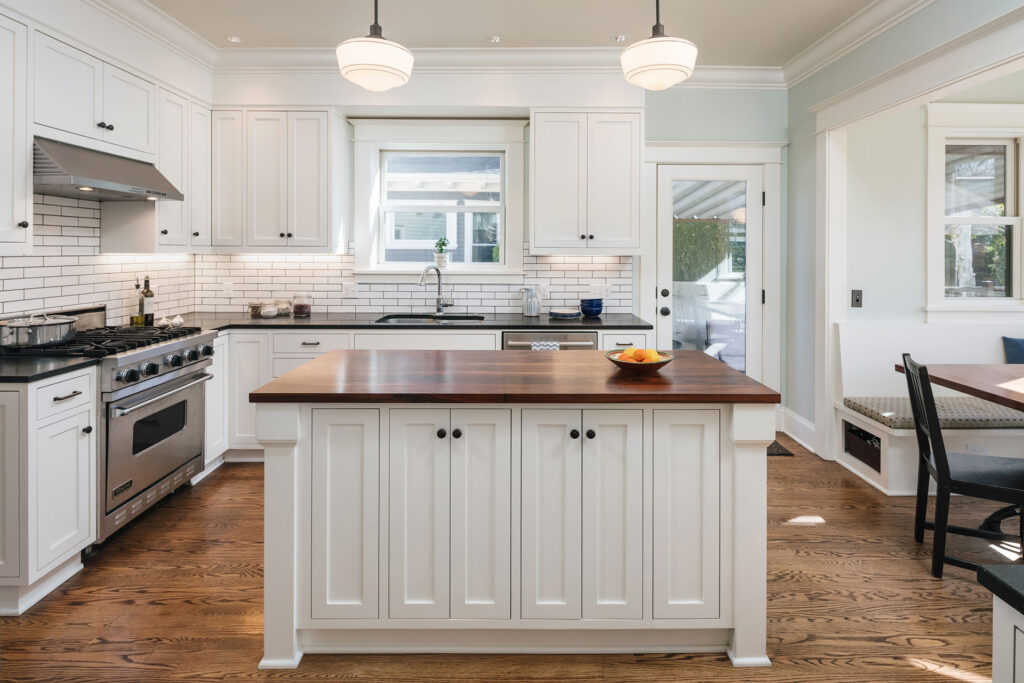 An island with a walnut butcher block countertop is the central focal point of the renovated kitchen at the Laurelhurst Craftsman.