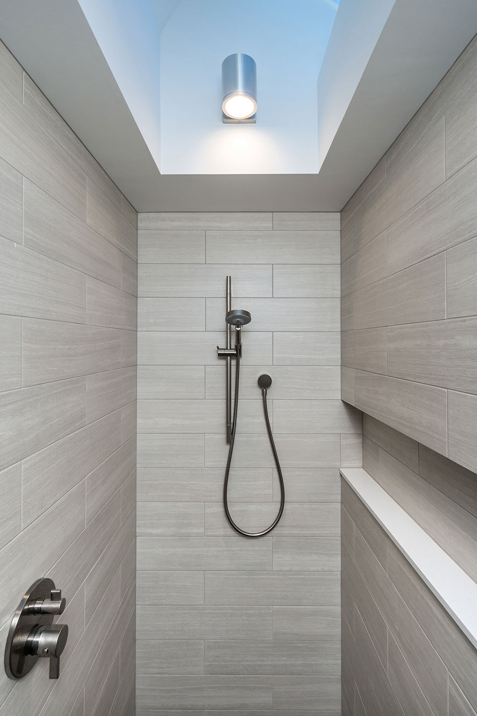 A large skylight is centered over the primary bathroom shower at the Modern Farmhouse.