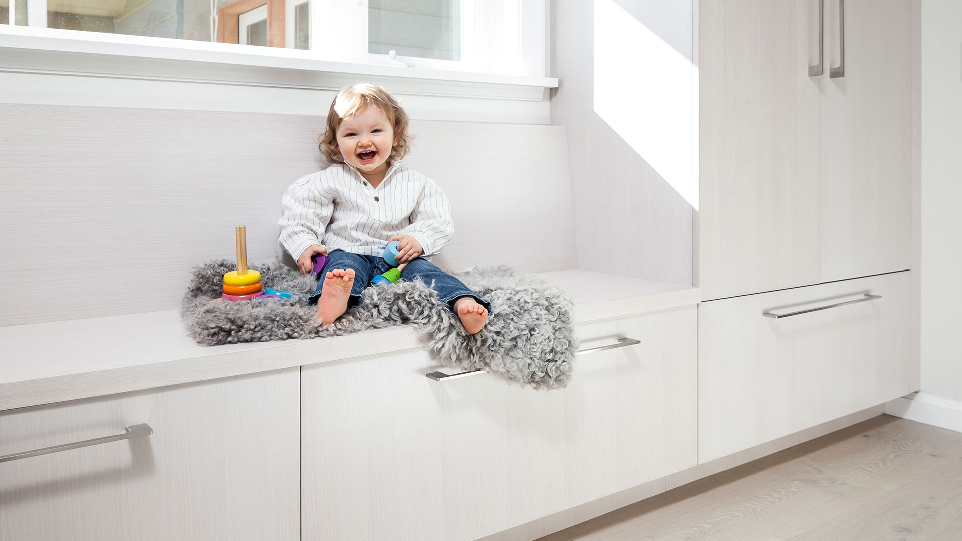 The custom bench and cabinetry in the primary suite provides a play place for the owner's daughter.