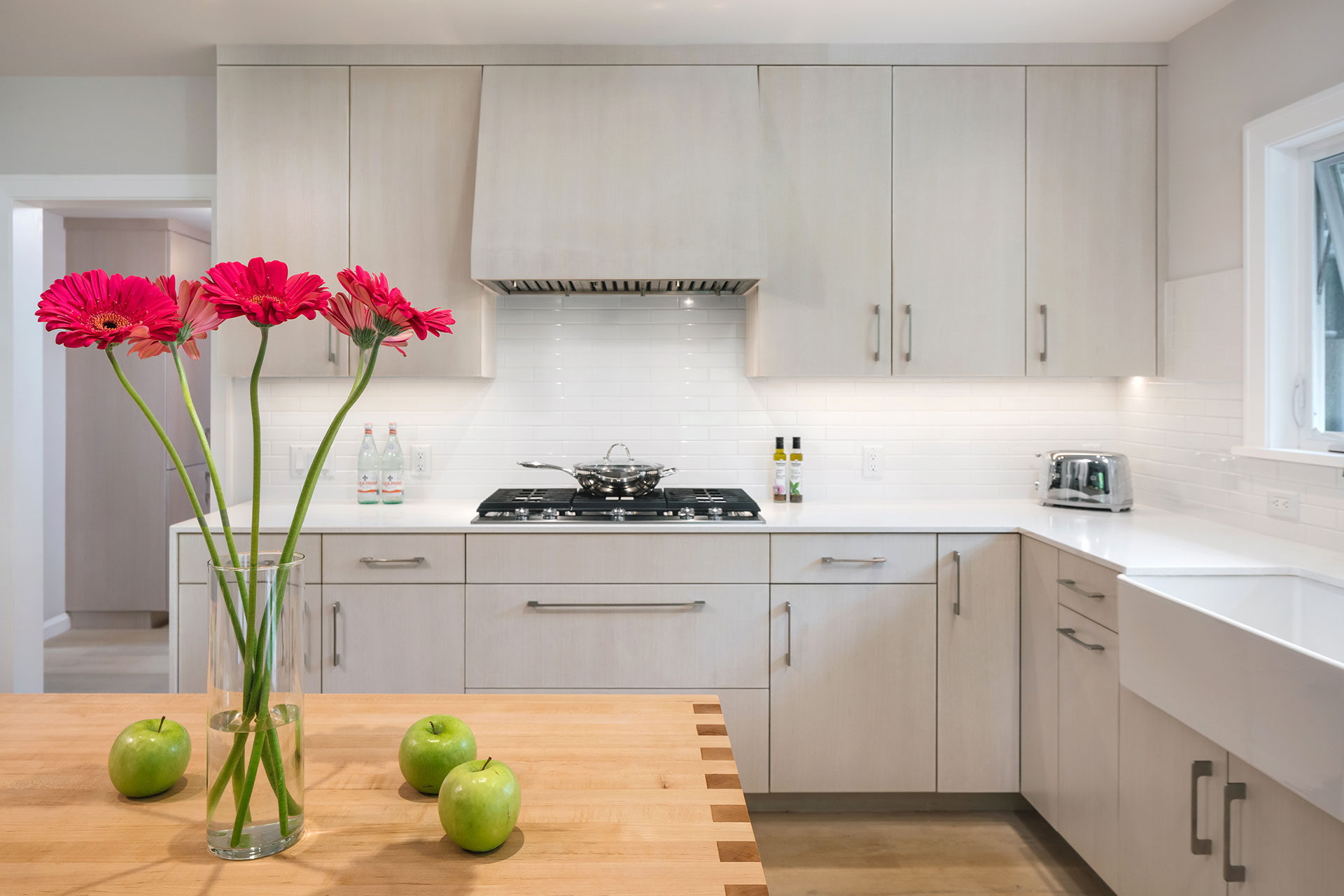 A maple butcher block island with a finger jointed waterfall edge detail is part of this modern farmhouse remodel.