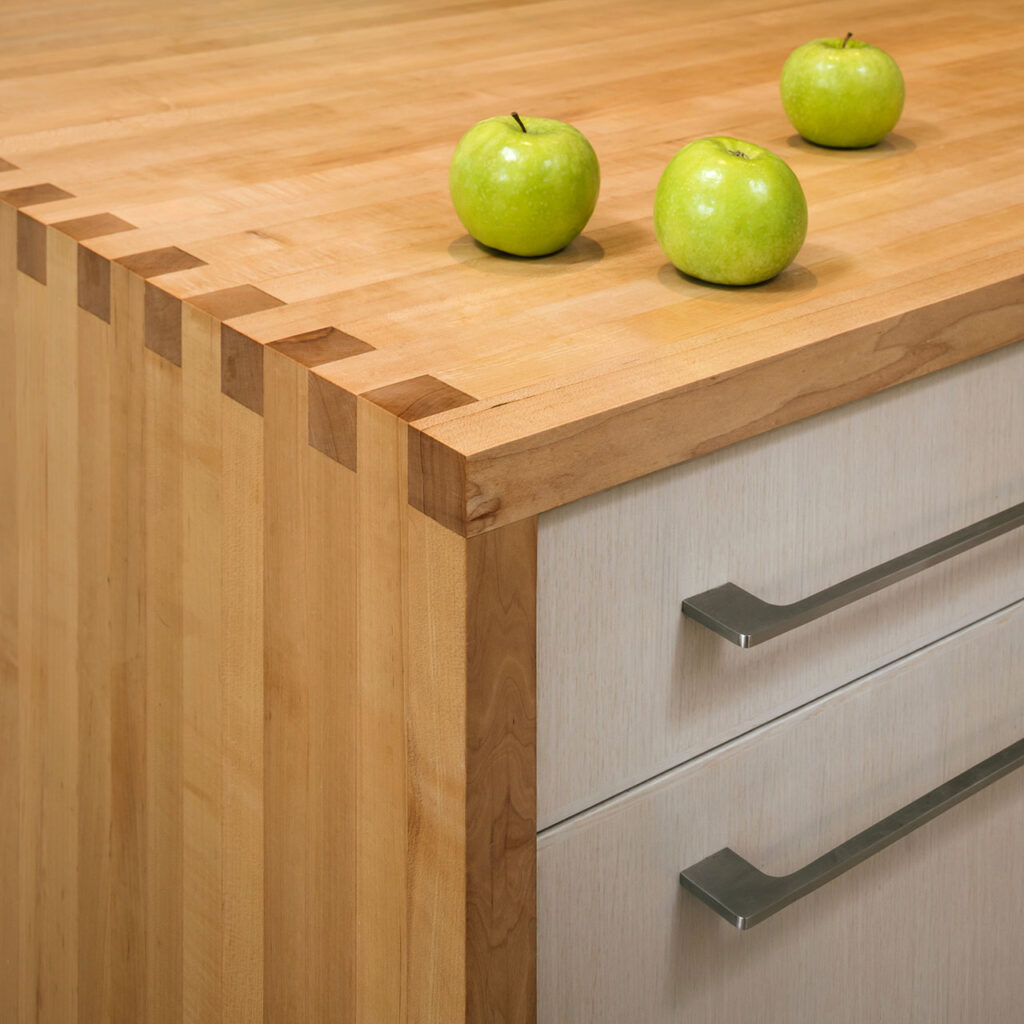 The island countertop is crafted from maple and finger-jointed at the waterfall edge at the Modern Farmhouse.