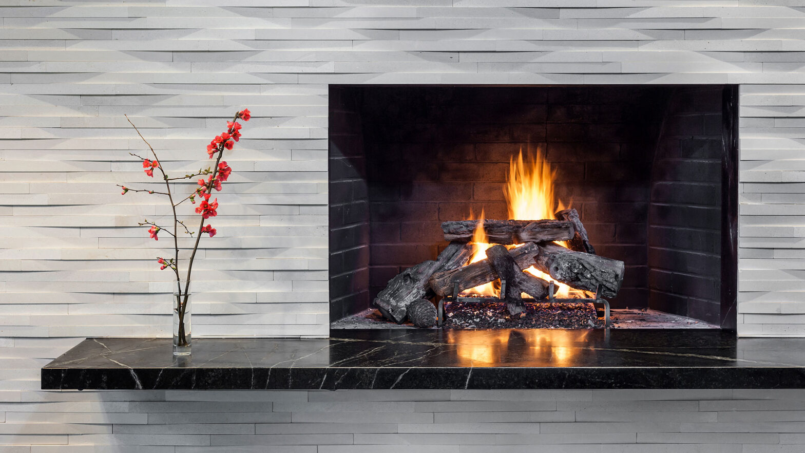 The fireplace is surrounded by cut stone tile and a black marble hearth at the Patton Modern.