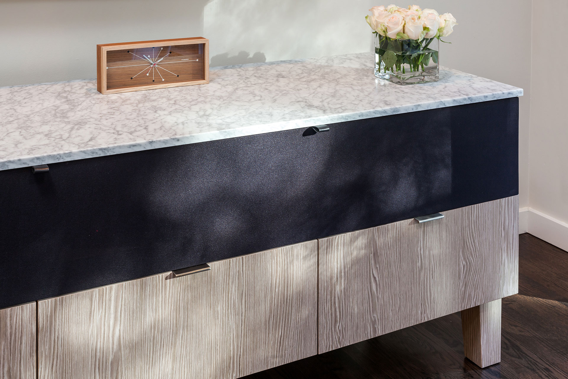 Carrara marble and white oak are used to create a custom stereo cabinet in this mid-century modern remodel.