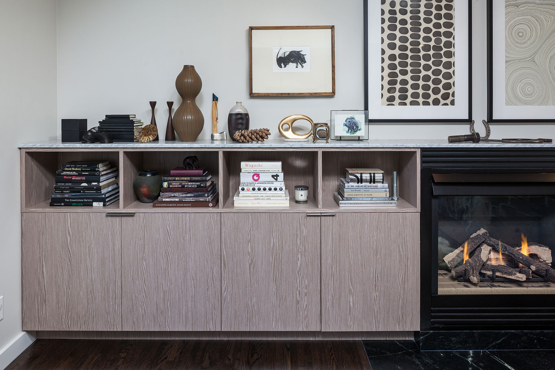 White oak cabinetry surrounds a gas fireplace in this mid-century modern remodel.