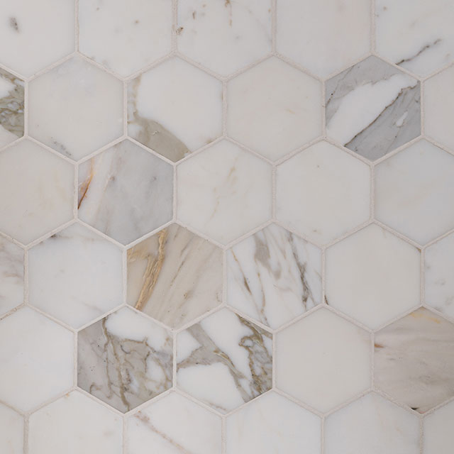 The primary bathroom floor is tiled with hexagon-shaped Calacatta marble.
