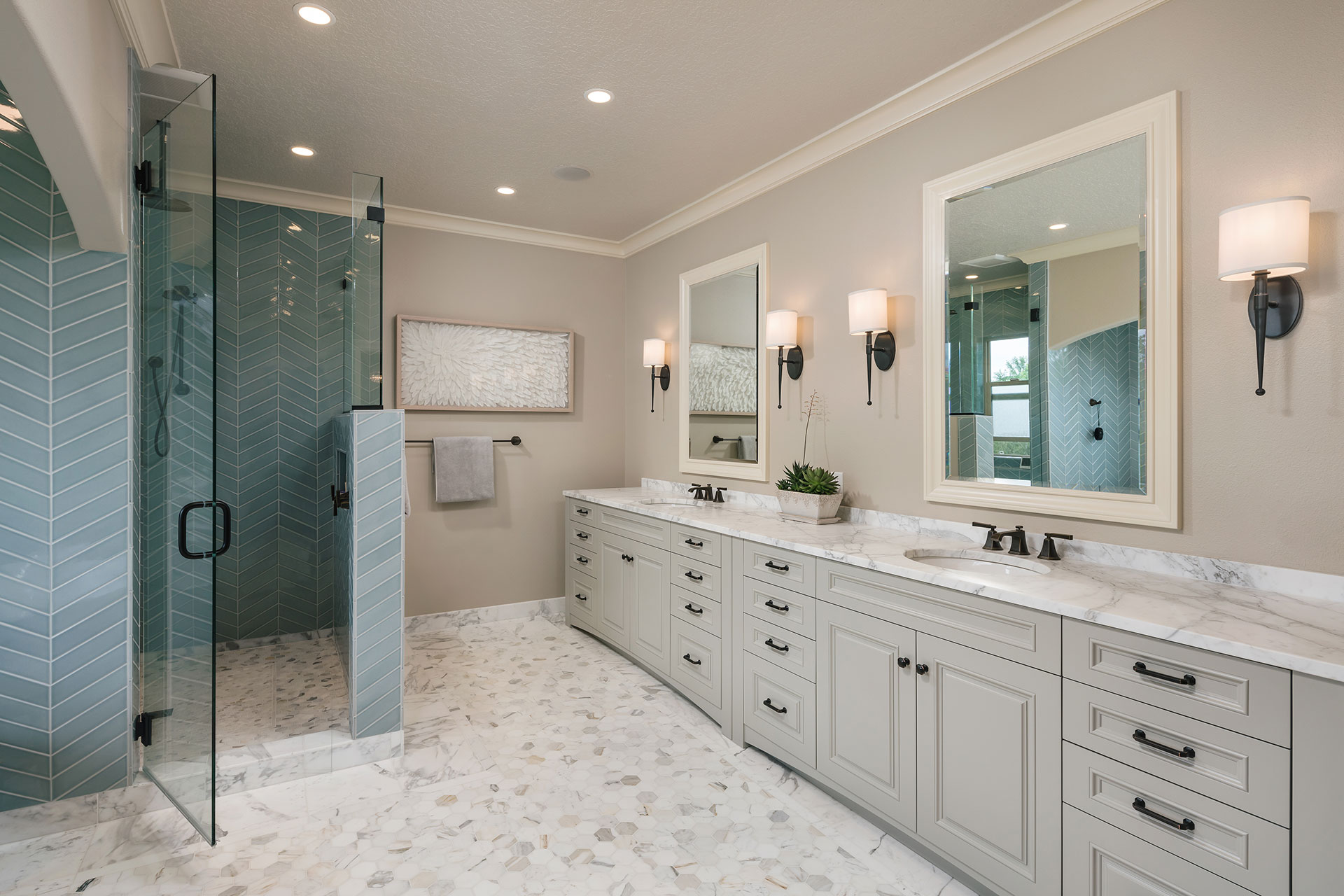 The primary bathroom at features a new double vanity and large shower as part of the whole house interior remodel. The floors and countertop are Calacatta marble.