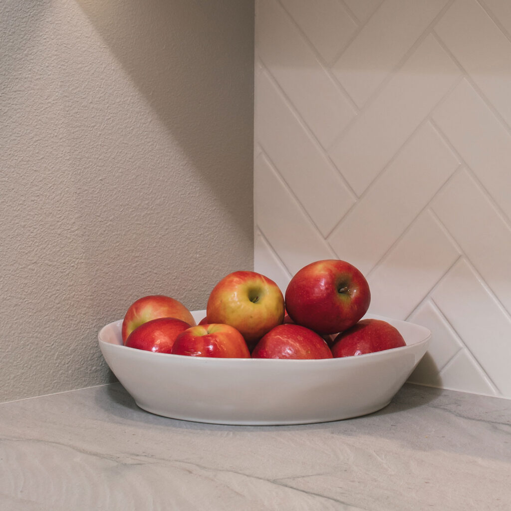 A bowl of shiny red apples sits on the buffet counter.