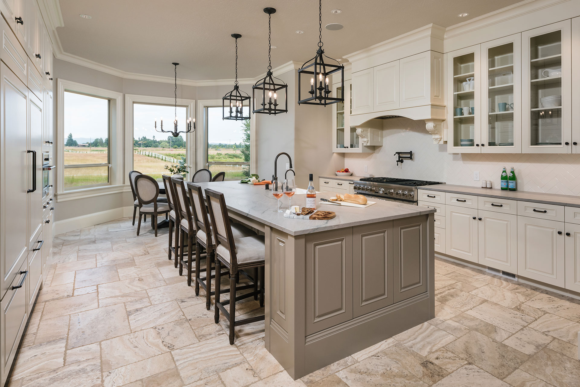 The renovated kitchen features a large island, a gas range with custom hood and two dishwashers after the whole house interior remodel.