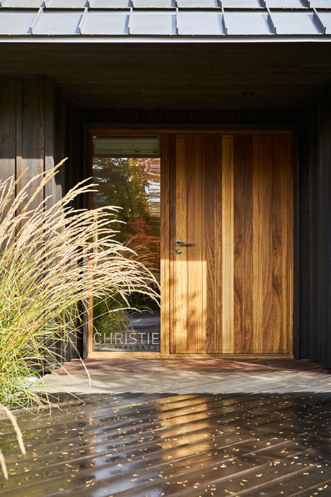 A large pivot door with glass sidelite welcomes visitors to the Studio.