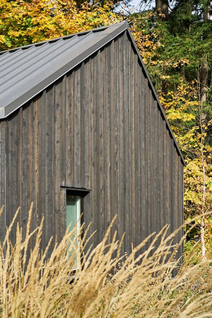 The Christie Architecture Studio is clad with black-stained cedar board and batten siding.