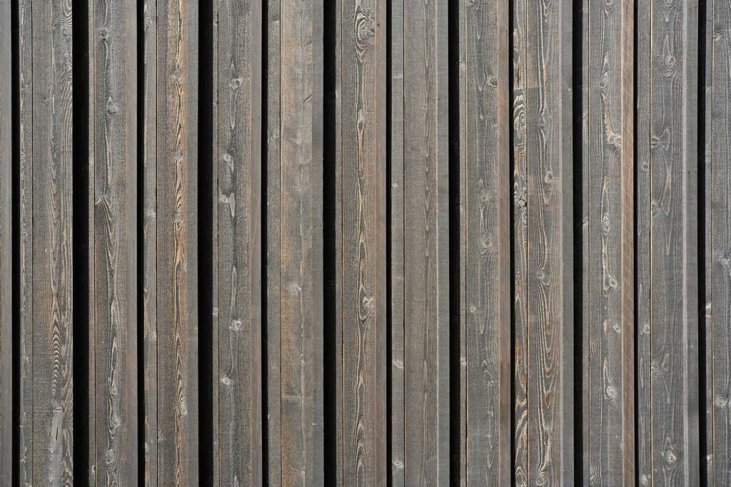 Black-stained cedar board and batten siding creates a pattern of shadows on the exterior of the Christie Architecture Studio.