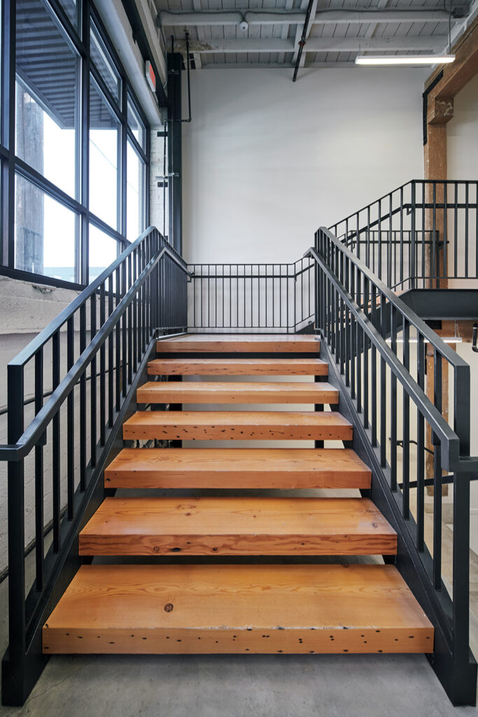 Stairs crafted from timbers reclaimed from the original building create a focal point in the lobby of the Taylor Building which was designed by Christie Architecture in Portland Oregon.