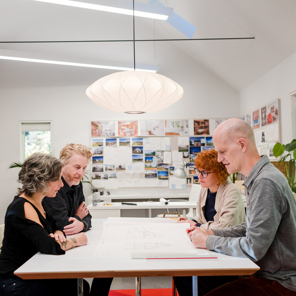 Adam and Lisa Christie discussing drawings with their clients, at their Portland architecture office.