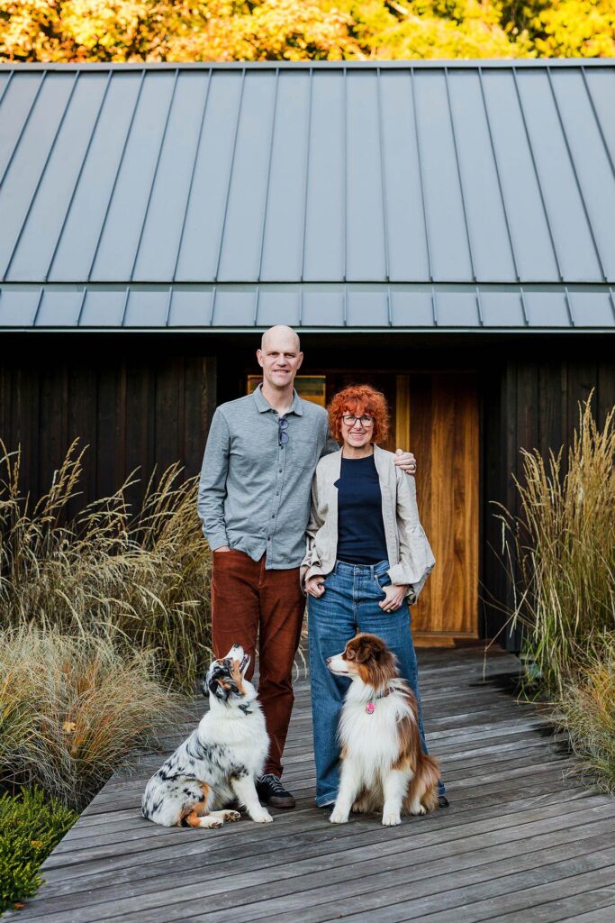Adam and Lisa Christie with the office dogs, Luna and Stella, standing in front of their Portland architecture office.