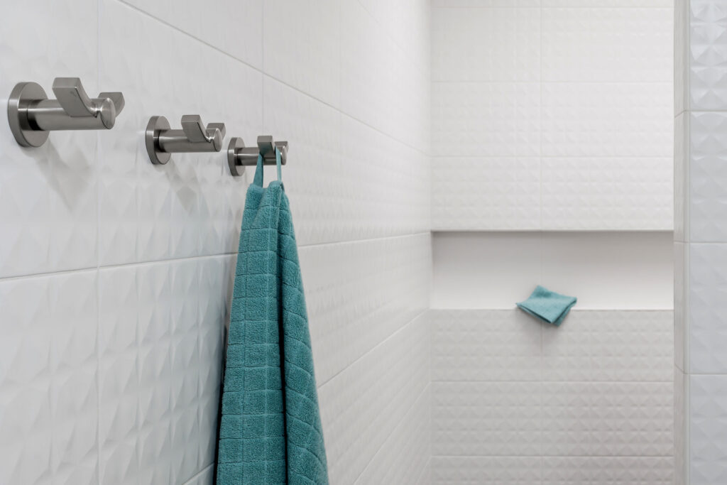 The primary bathroom shower is tiled with a textured ceramic tile. A shampoo niche features across the back of the shower.