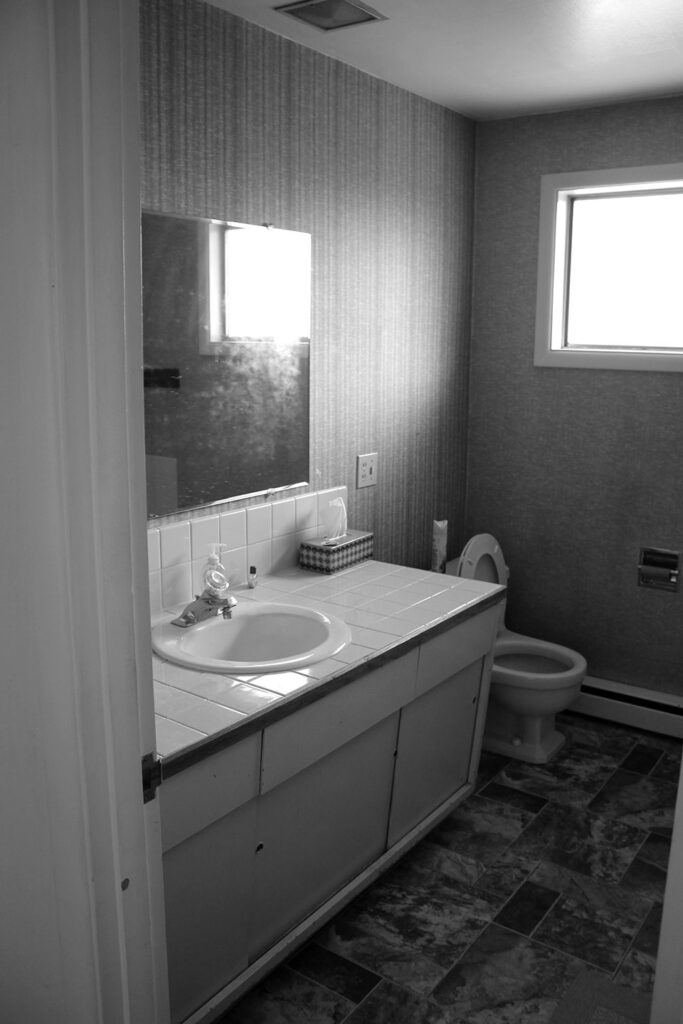 Before the mid-century home remodel, the old guest bathroom was dark and out of date.