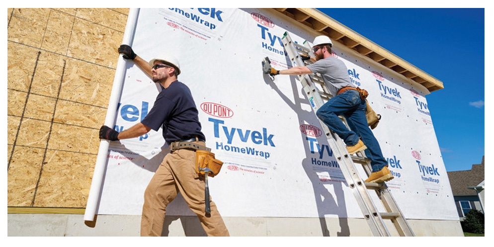 Construction workers installing a water resistive barrier.