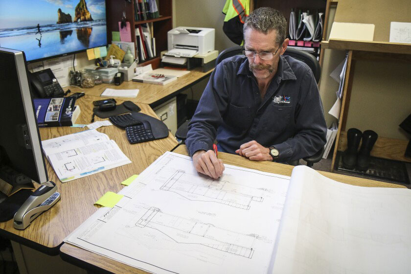 A plan reviewer reviews the drawing at his desk, out of context with actual site conditions.