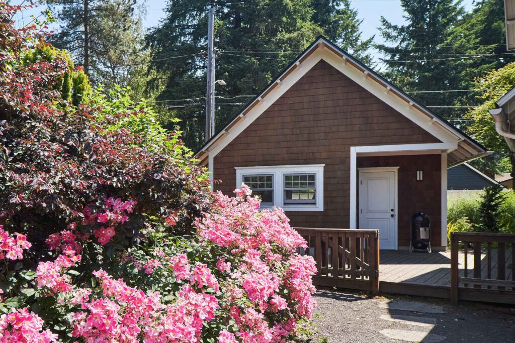 The rear elevation of Craftsman Garage features double hung windows. A door leads to a deck which connects back to a side door on the house.