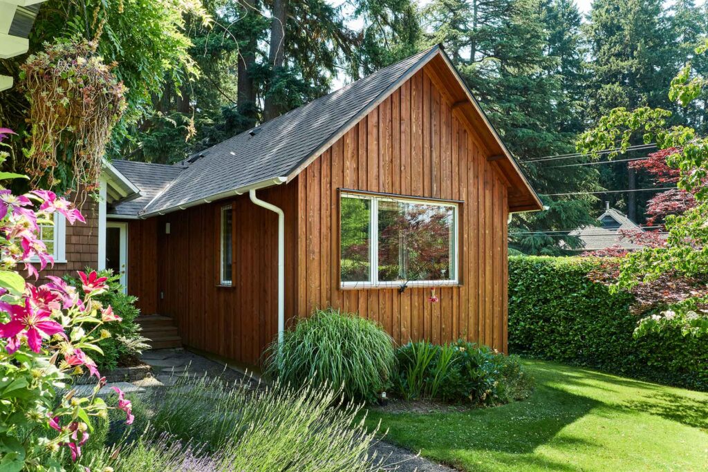 The rear elevation of the primary suite addition features a large window that faces the yard.