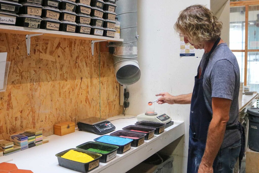 Jason Coleman mixing dry powder dyes to make the ceramic tile glaze.