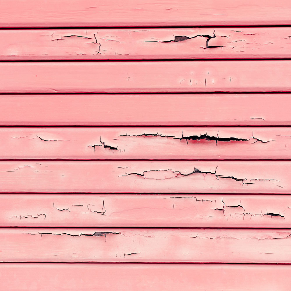 Exterior wood siding with chipping pink paint that likely has lead in it.