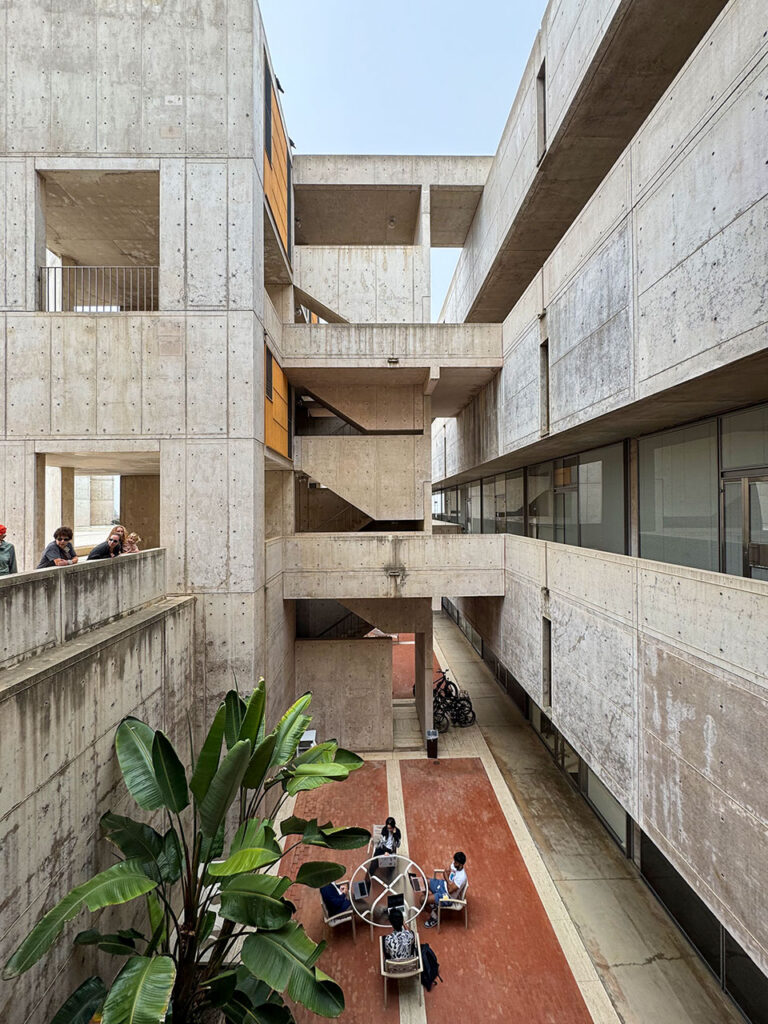 View looking into a recessed light well with a gathering space at the bottom at the Salk Institute.