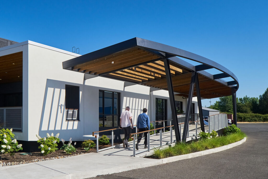 Commercial building entry with integrated ADA ramp improving accessible path of travel as part of the 25% accessibility rule considerations during a renovation.